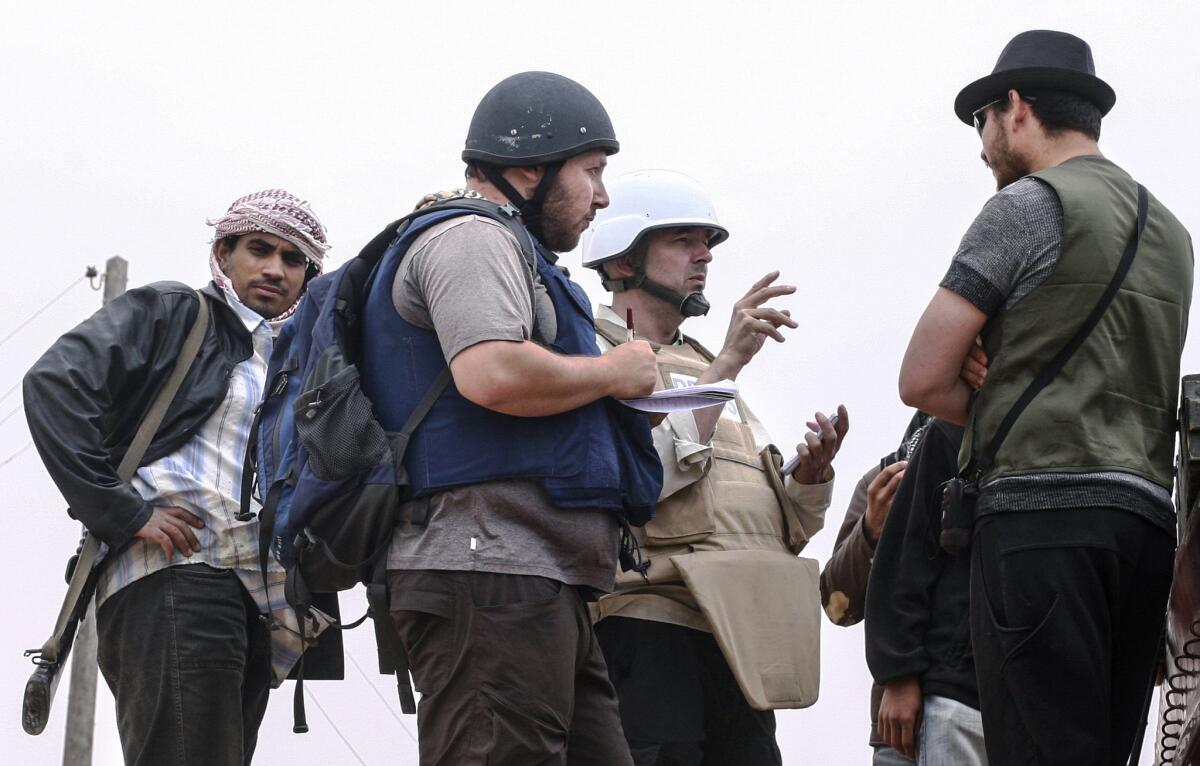 Steven Sotloff, in black helmet, talks with rebels in Libya on June 2, 2011.