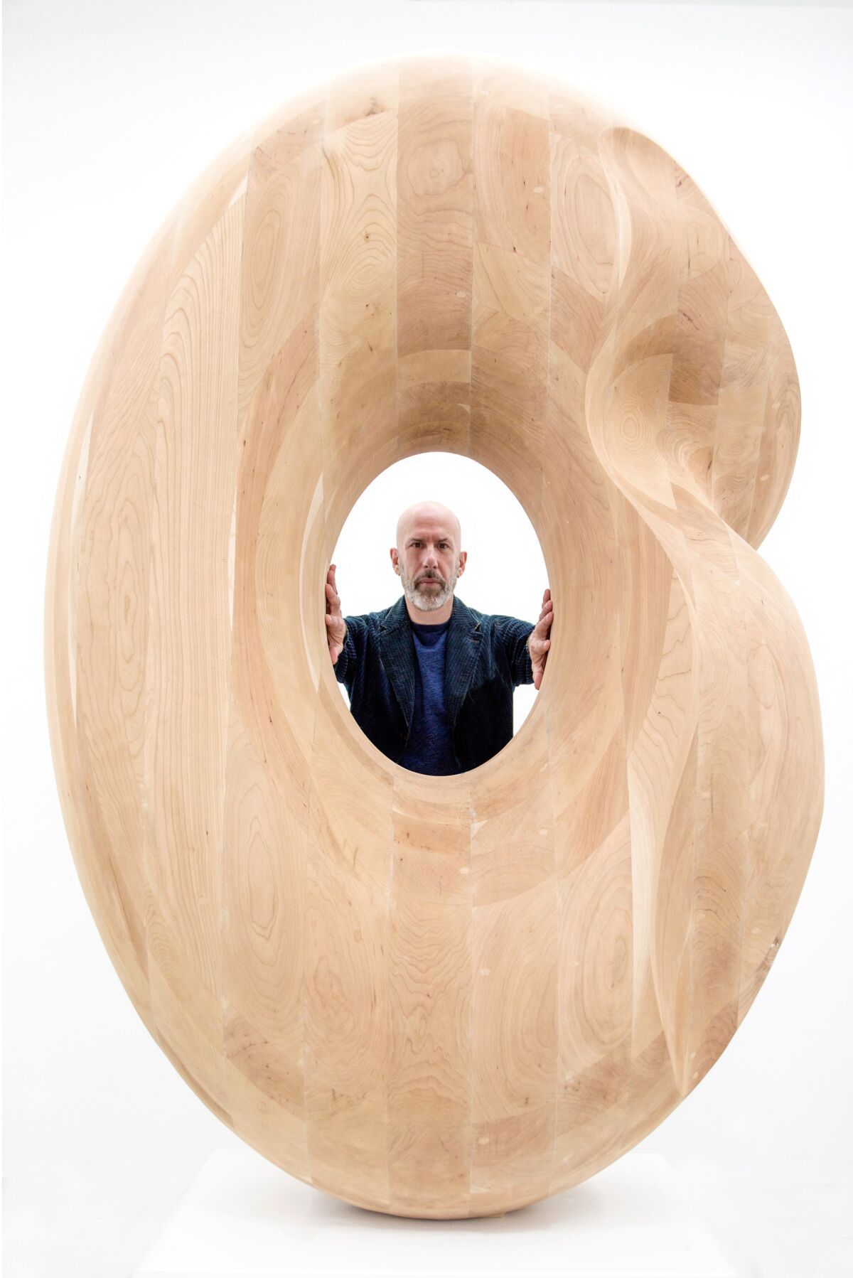 Artist Douglas Tausik Ryder with one of his technology-assisted wooden sculptures.