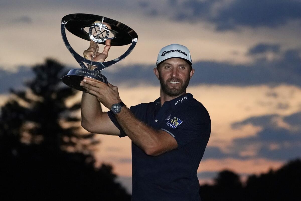 Dustin Johnson holds the trophy after winning the Northern Trust golf tournament.