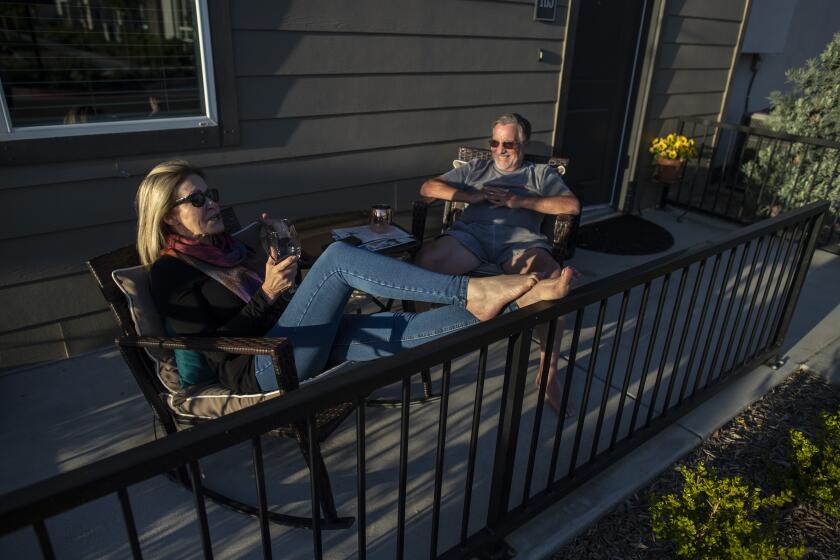 FRESNO, CA - MARCH 23: Bree McDowel, left, and Bill Van Heusen, right, enjoy the sunset from their patio at The Row, a new apartment development on Tuesday, March 23, 2021 in Fresno, CA. (Brian van der Brug / Los Angeles Times)