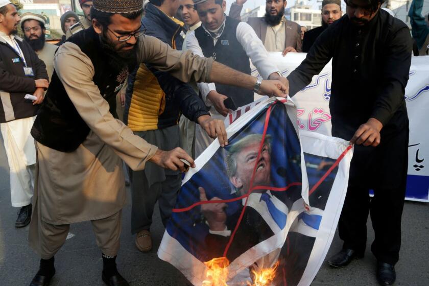 Pakistani protesters burn posters of U.S. President Donald Trump in Lahore, Pakistan, Friday, Jan 5, 2018. A senior Pakistani senator has expressed disappointment at the U.S. decision to suspend military aid to Islamabad, saying it will be detrimental to Pakistani-U.S. relations. Nuzhat Sadiq, the chairwoman of the Senate Foreign Affairs committee in the upper house of parliament, says Islamabad can manage without the United States as it did in the 1990s, but would prefer to move the troubled relationship forward.(AP Photo/K.M. Chaudary)