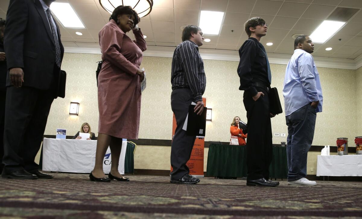 Job seekers line up to meet a prospective employer at a career fair at a hotel in Dallas.