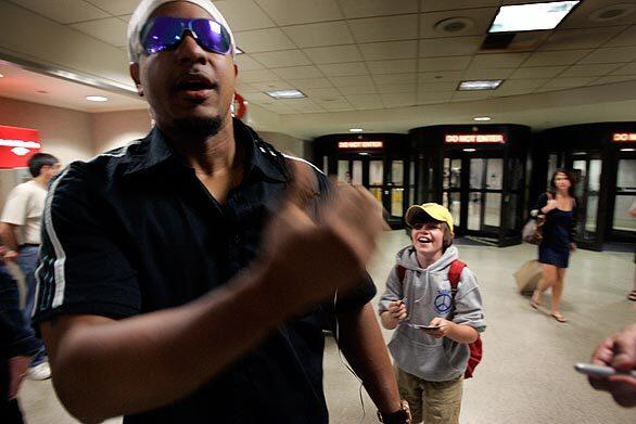 Manny Ramirez arrives at Los Angeles International Airport from Boston as fan Charlie Leonard, 11, looks for an autograph on August 1, the day after he was traded to the Dodgers from the Red Sox.