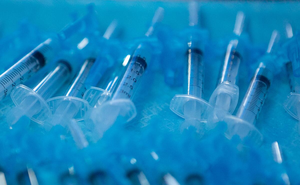 A tray of  syringes with filled COVID-19 vaccine.