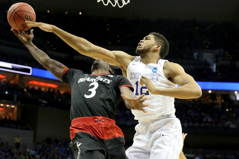 Kentucky's Karl-Anthony Towns, right, tries to block a shot by Cincinnati's Shaquille Thomas during a Wildcats' victory.