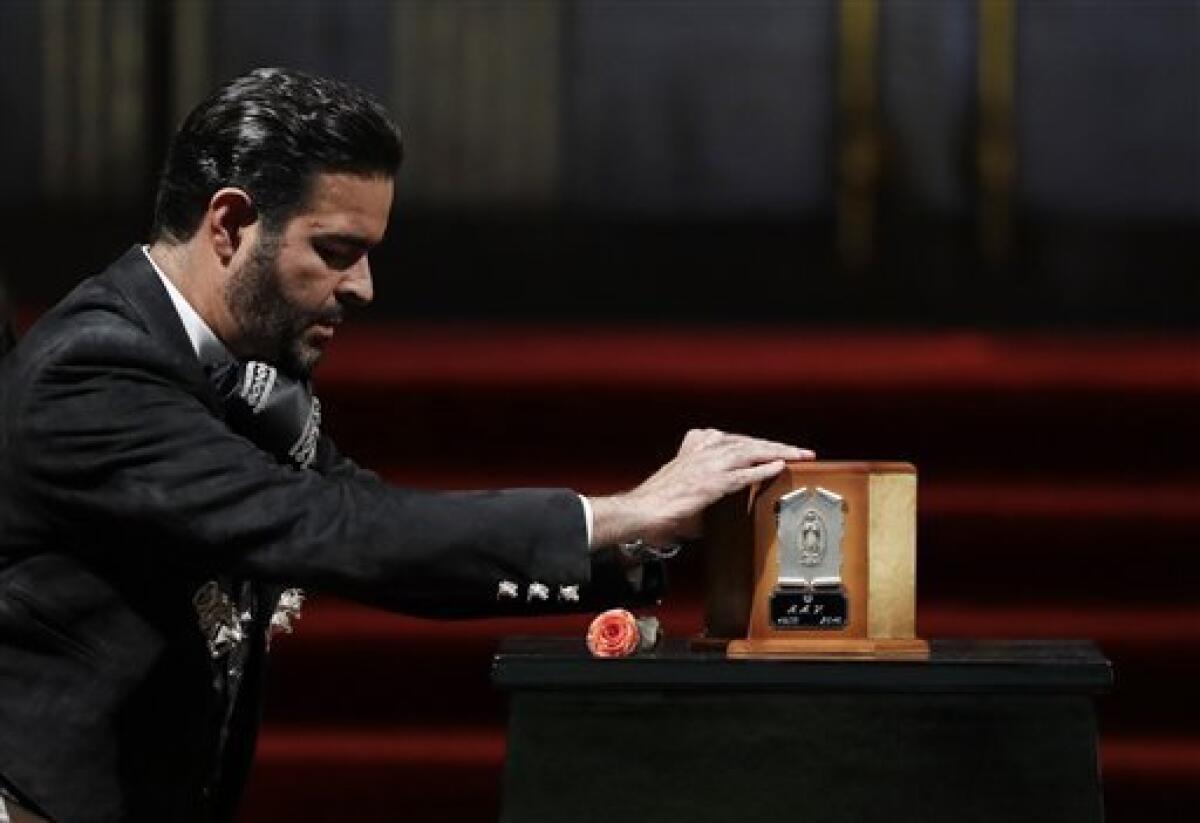 El cantante Pablo Montero toca la urna con las cenizas de Juan Gabriel para decir adiós al superastro de la música mexicana, el lunes 5 de septiembre del 2016 en el Palacio de Bellas Artes, en la Ciudad de México.