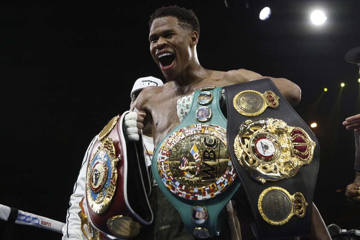 Devin Haney celebrates with his championship belts after defeating George Kambosos Jr. in October 2022.