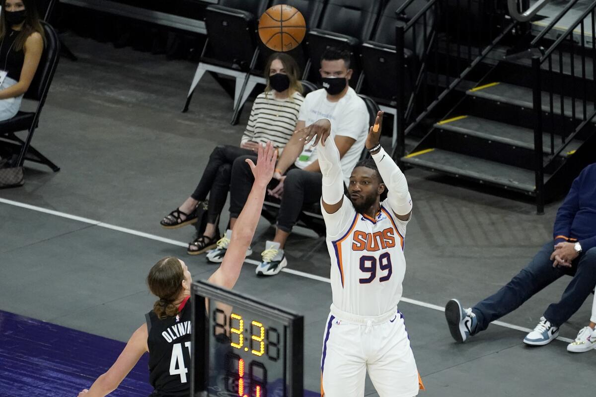 Phoenix Suns forward Jae Crowder (99) shoots a three pointer over Houston Rockets forward Kelly Olynyk during the first half of an NBA basketball game, Monday, April 12, 2021, in Phoenix. (AP Photo/Matt York)