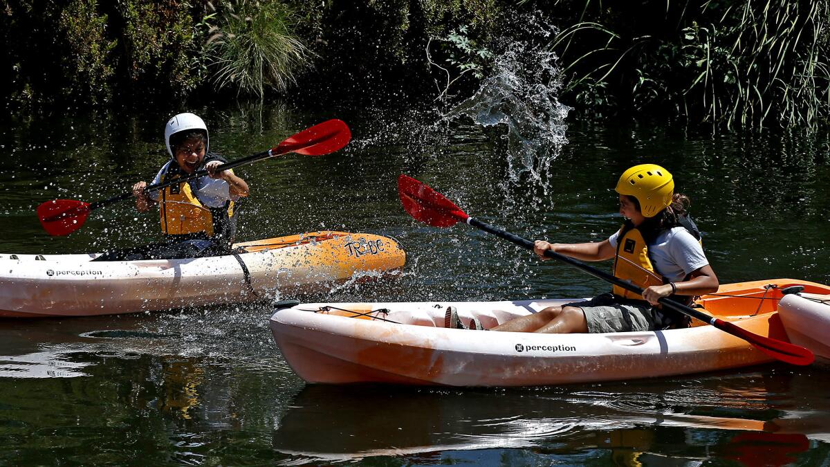 Emmy Rodriguez, 16, left, splashes Julie Anaya, 17, as they kayak along the L.A. River as part of their LEAF internship.