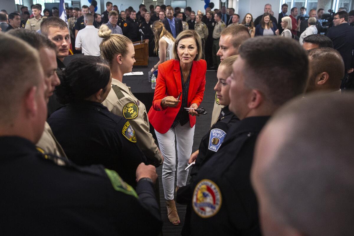 A woman hands out pens to law enforcement officers from a variety of agencies