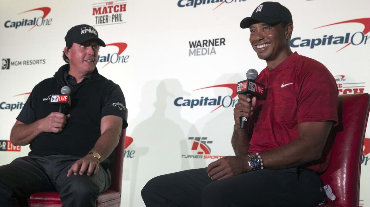 Phil Mickelson, left, and Tiger Woods speak during a news conference at Shadow Creek Golf Course in Las Vegas on Nov. 20.