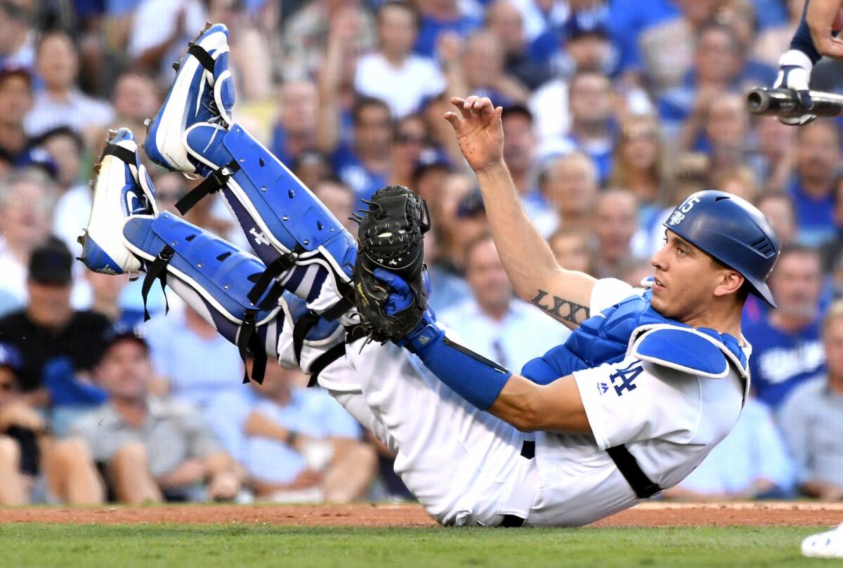 Dodgers catcher Austin Barnes falls the ground after catching a foul ball.