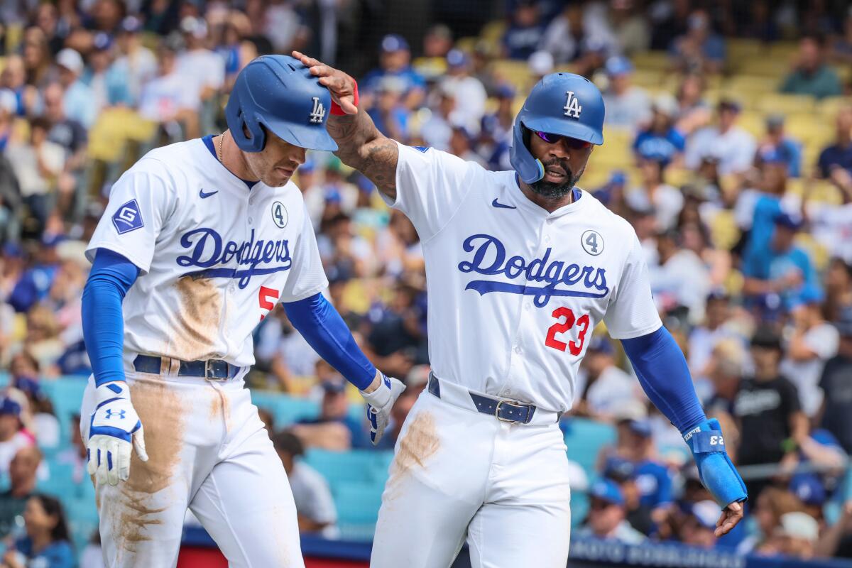 Dodgers outfielder Jason Heyward, right, congratulates Freddie Freeman against the Rockies.