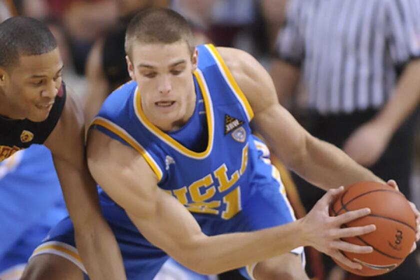 UCLA's Brendan Lane, right, grabs a loose ball away from USC's Bryce Jones during a 2011 game. Lane may have graduated from UCLA, but that isn't stopping him from making a valuable contribution on the court for Pepperdine this season.