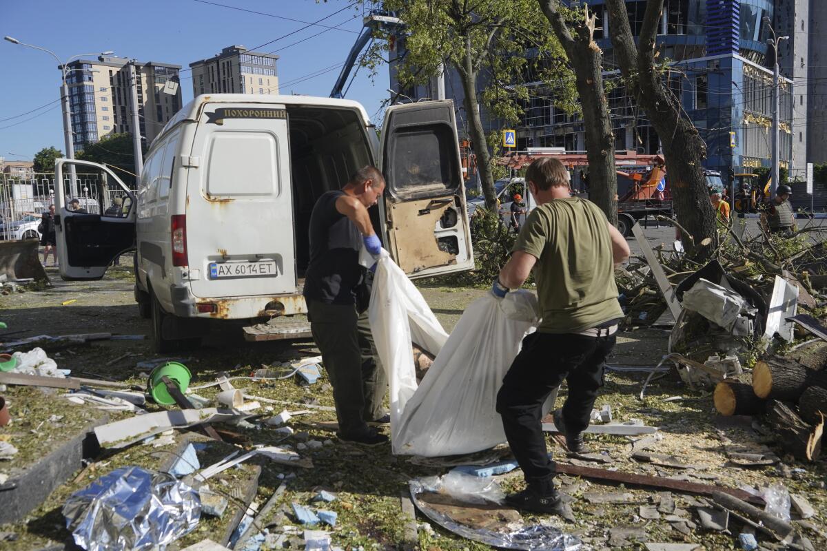 A body is carried in a sheet after a Russian airstrike in Kharkiv, Ukraine.