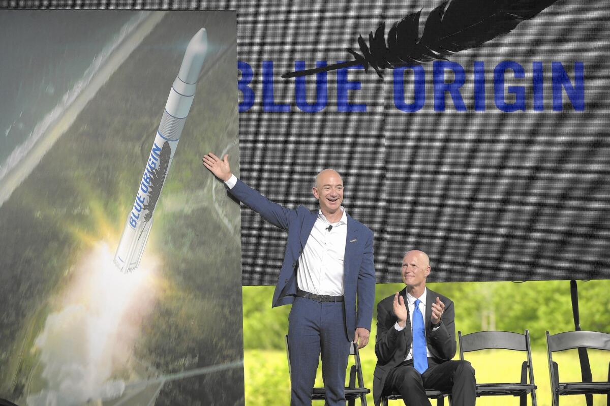 Amazon CEO Jeff Bezos, left, unveils the new Blue Origin rocket as Florida Gov. Rick Scott applauds at the Cape Canaveral Air Force Station in Florida.