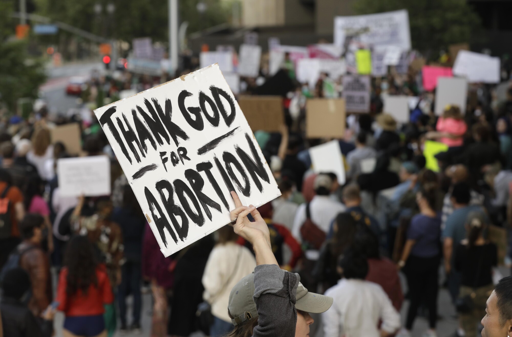 A protester holds up a sign that says "Thank God for abortion"