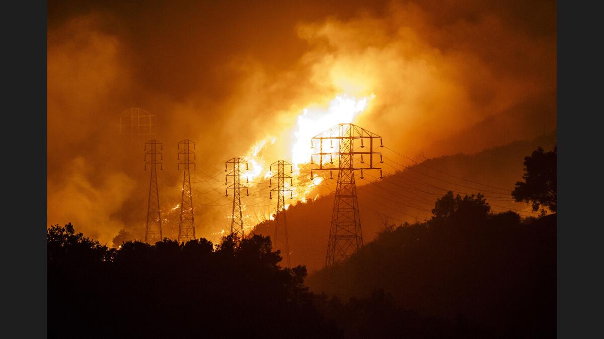 Flames whip around power lines during the Thomas fire in 2017, which was one of more than 2,000 fires caused by malfunctioning electrical equipment since 2014.