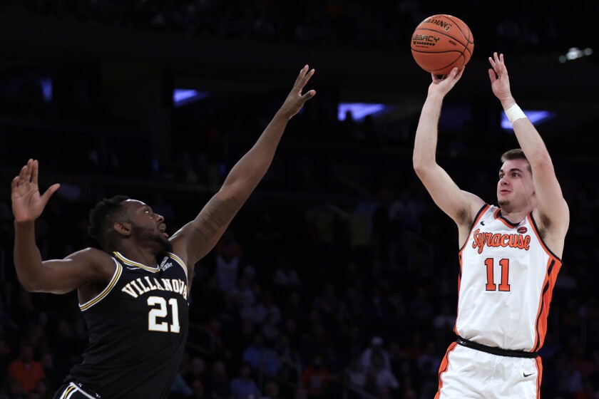 Syracuse guard Joseph Girard III (11) shoots over Villanova forward Dhamir Cosby-Roundtree during the first half of an NCAA college basketball game in the Jimmy V Classic on Tuesday, Dec. 7, 2021, in New York. (AP Photo/Adam Hunger)