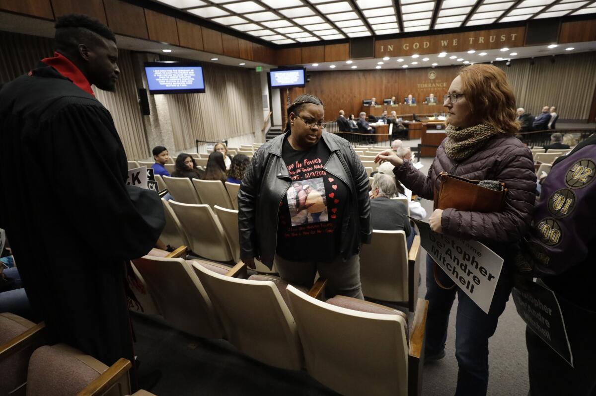 The mother of a police shooting victim is escorted out of a city council meeting