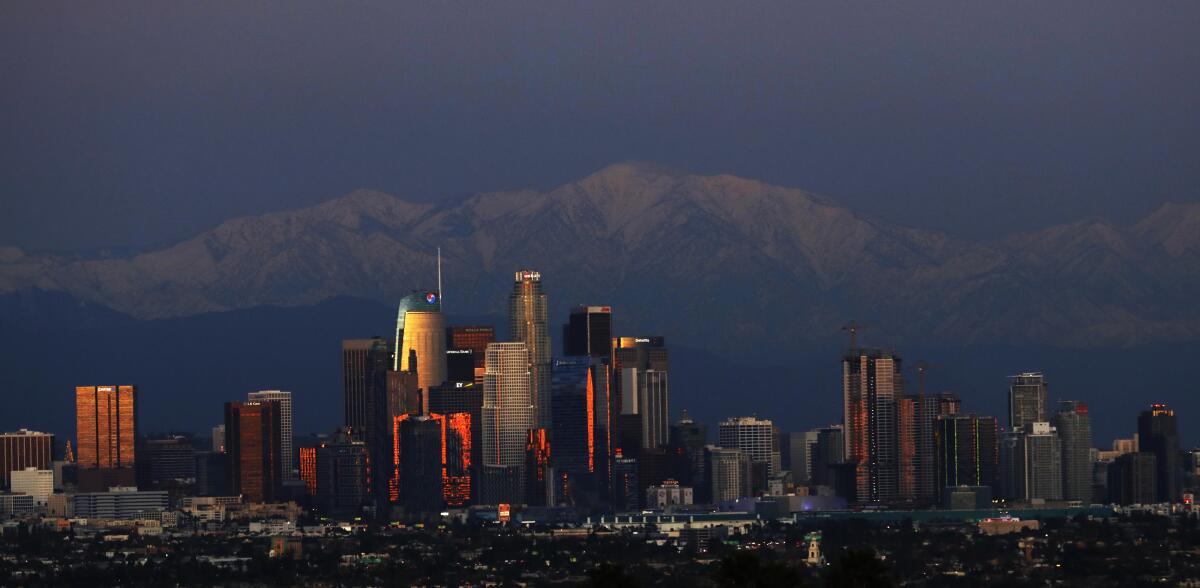 Snow-covered San Gabriel Mountains provide a wintry backdrop for the downtown Los Angeles skyline on Dec. 27, 2019.