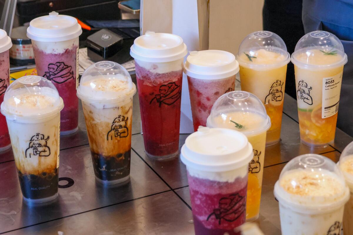 An array of colorful drinks in plastic cups, waiting to be picked up by customers at Heytea