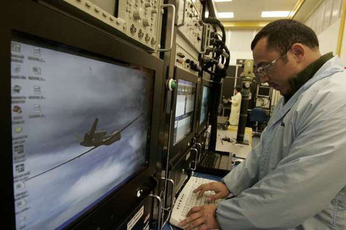 Raytheon employee Jorge Gonzalez tests the accuracy of the Global Hawk drone's sensory system at the company's space and airborne systems unit headquarters in El Segundo.
