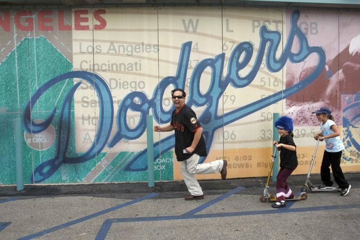 Ric Salinas of Culture Clash, the trio that reigns as undisputed clown princes of L.A. bilingual theater, has a laugh at Dodger Stadium with his daughters Daisy, 7, and, at right, Lola, 8.