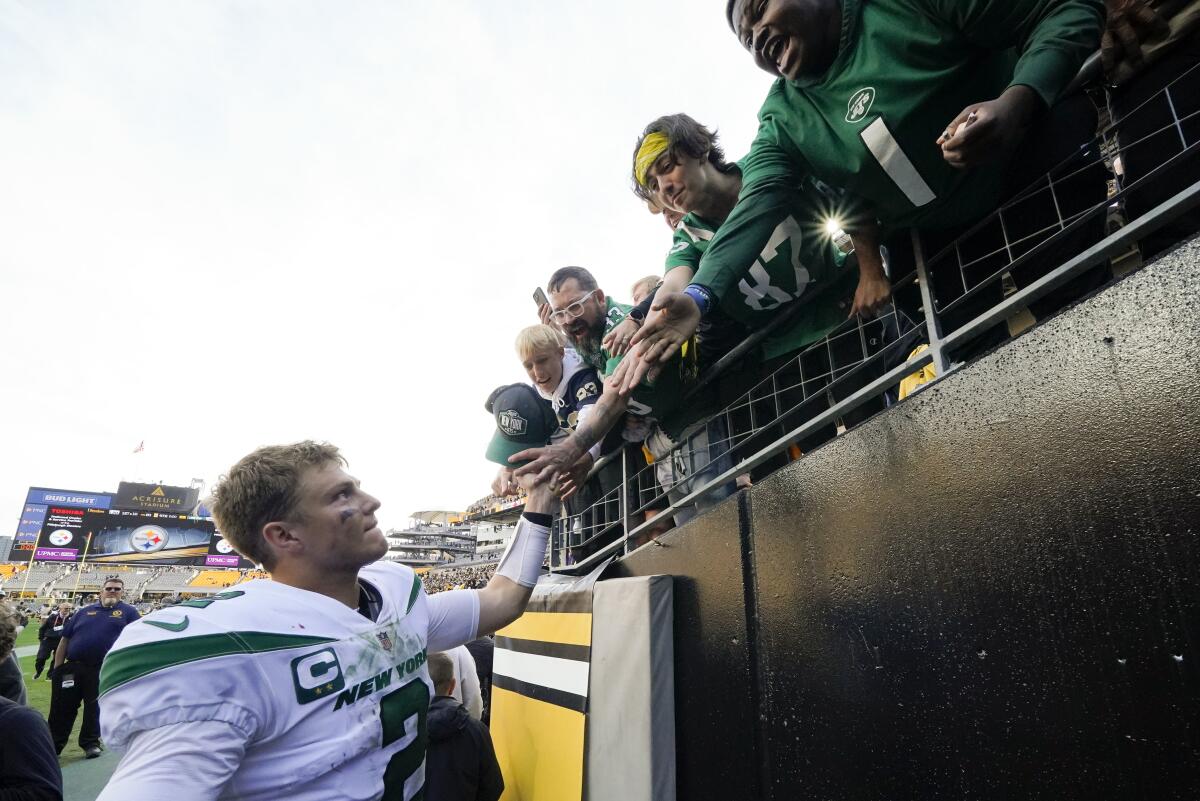 New York Jets quarterback Zach Wilson (2) greets fans as he heads to the locker room after during an NFL football game against the Pittsburgh Steelers, Sunday, Oct. 2, 2022, in Pittsburgh. (AP Photo/Gene J. Puskar)