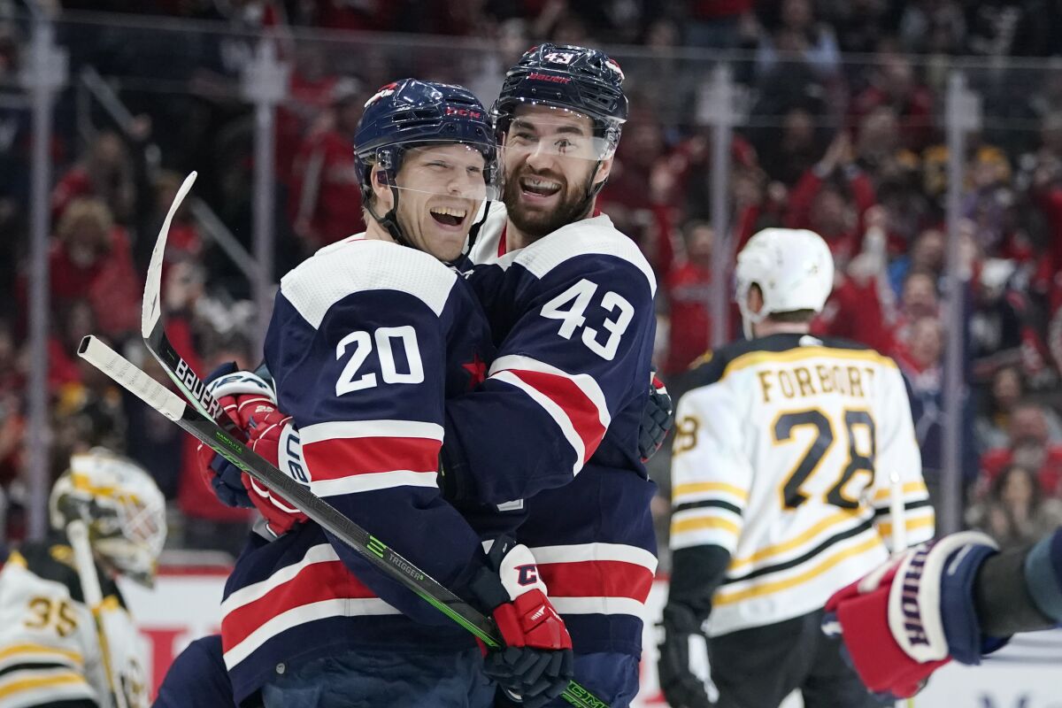 Washington Capitals center Lars Eller (20) celebrates his third period goal with right wing Tom Wilson (43) of an NHL hockey game against the Boston Bruins, Sunday, April 10, 2022, in Washington. The Capitals won 4-2. (AP Photo/Julio Cortez)