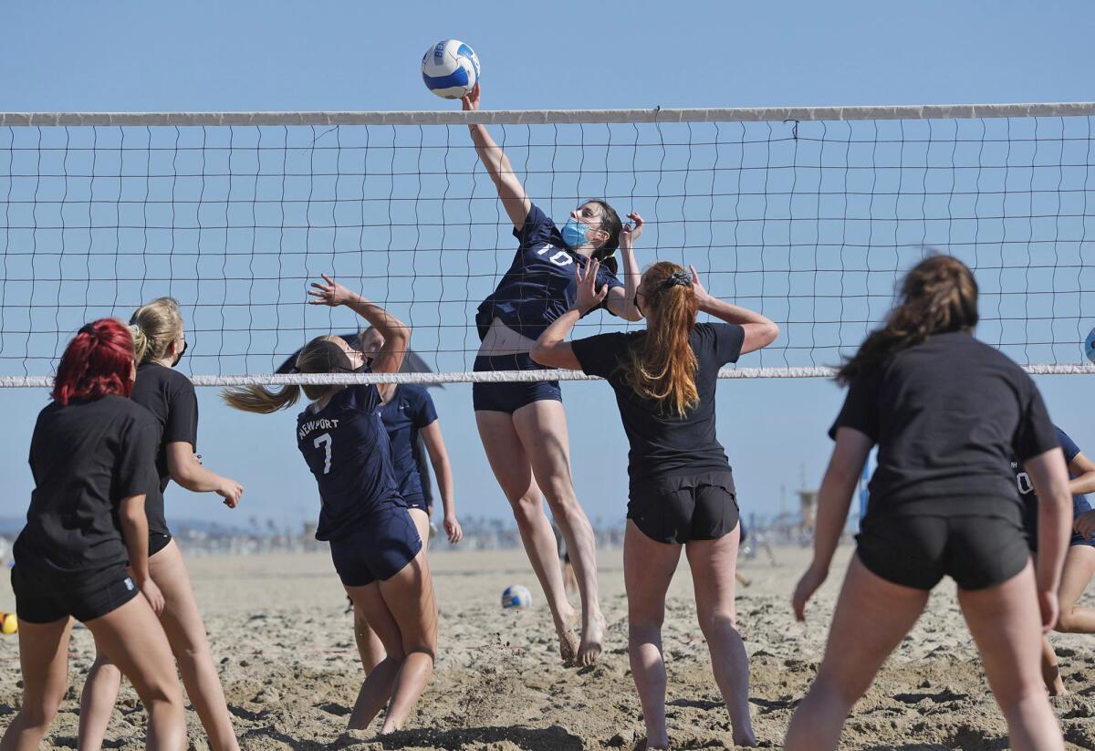 Newport Harbor's Annie O'Brien tips one over the net for a point during a beach volleyball match against Huntington Beach.