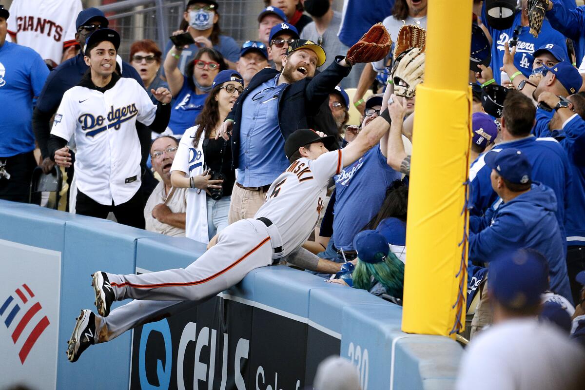 San Francisco Giants right fielder Mike Yastrzemski dives into the stands attempting to catch a home run.
