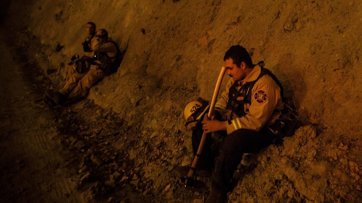 A firefighter takes a break during a burn operation Aug. 7 near Ladoga, Calif.