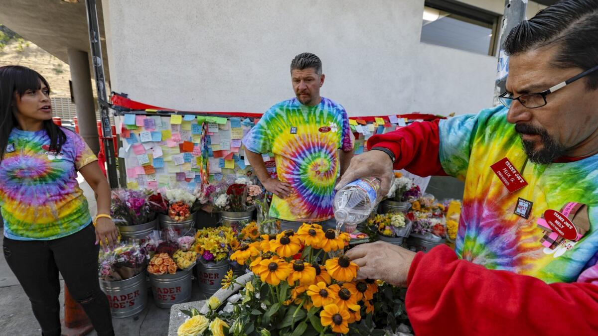 Trader Joe's employees wear tie-dye T-shirts in memory of their slain co-worker, Melyda Corado, on Thursday, the first day the store was open since the July 21 shootout.