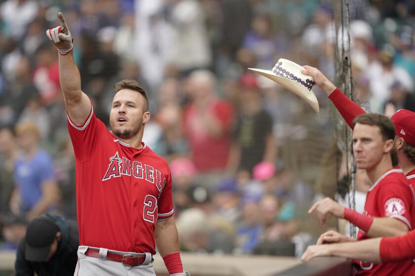 The Angels' Mike Trout points toward the outfield as he is greeted after hitting a go-ahead home run June 18, 2022.