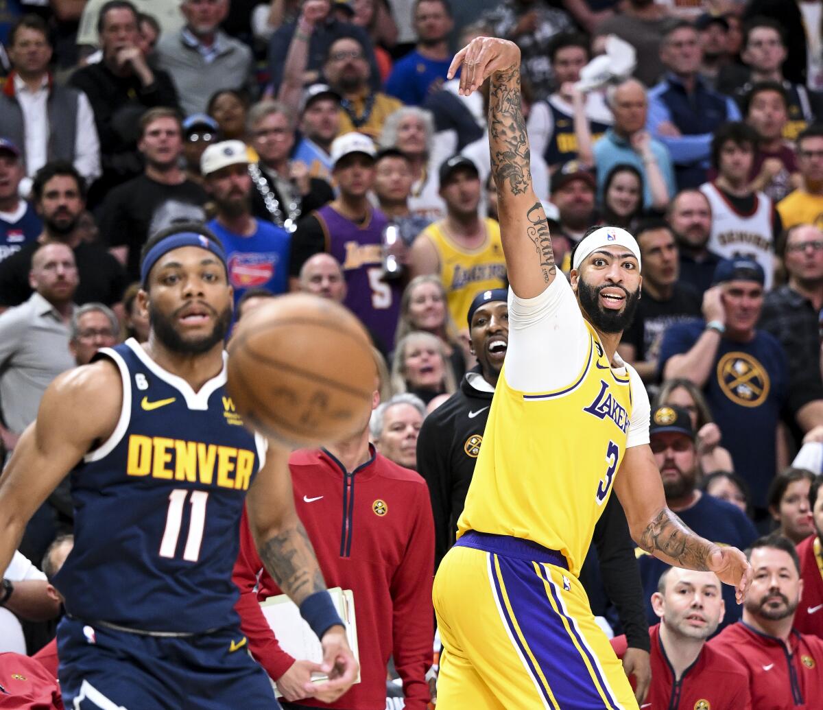 Lakers forward Anthony Davis watches his three-point shot while Denver Nuggets forward Bruce Brown looks on.