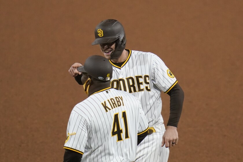 San Diego Padres' Wil Myers, right, reacts after hitting a single as first base coach Wayne Kirby (41) looks on during the seventh inning of a baseball game against the Pittsburgh Pirates, Monday, May 3, 2021, in San Diego. (AP Photo/Gregory Bull)