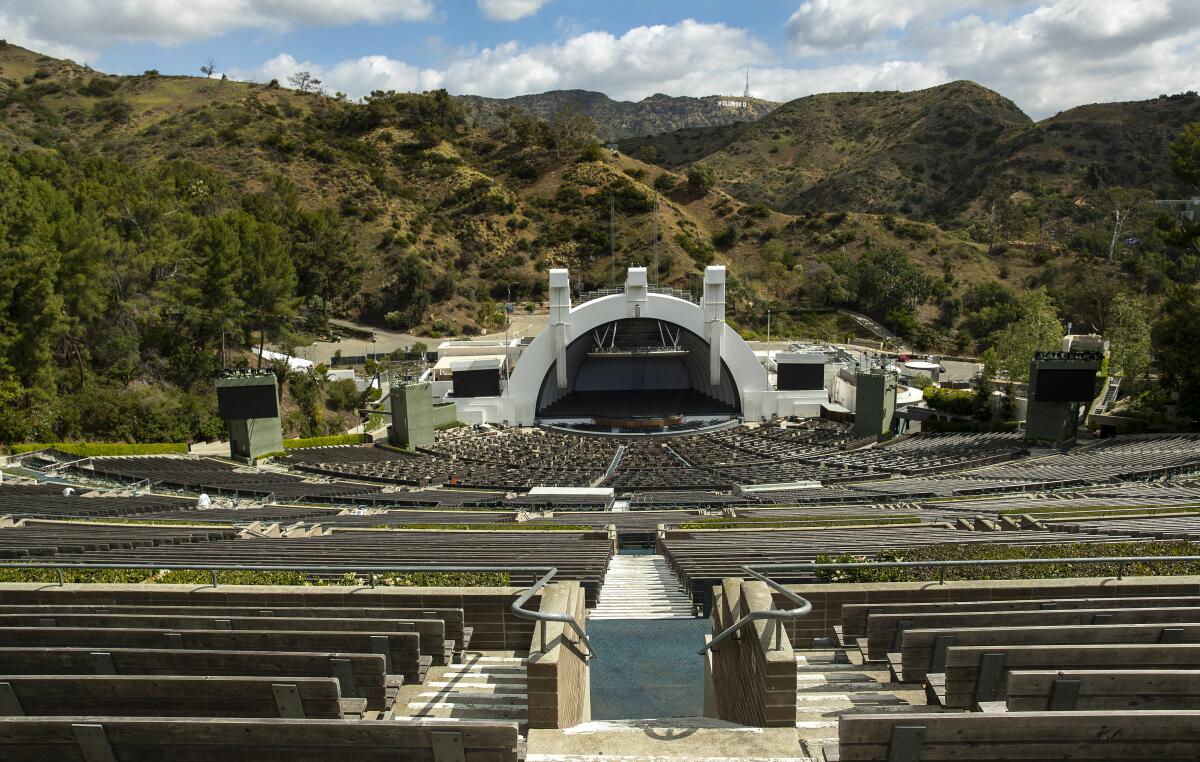 A high-up view shows the empty Hollywood Bowl amphitheater with the Hollywood sign visible on a distant hill.