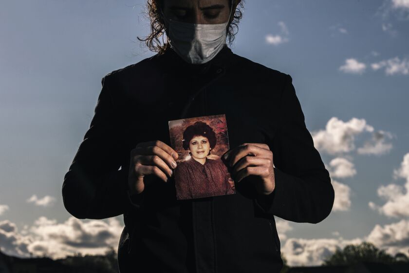 Amir, last name withheld, holds a photograph of his late mother, 68-year old Azar Ahrabi, who was Bay Area's first COVID-19 victim and the first case of community infection in Santa Clara County, stands for a portrait in Santa Clara, Calif. on Wednesday, March 25, 2020. MUST CREDIT Stephen Lam/San Francisco Chronicle