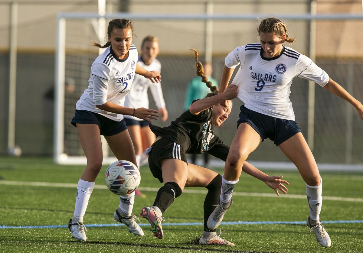 Newport Harbor's Lily Achak, left, and Sadie Hoch battle for control of a ball against CdM's Isabella Thomas on Thursday.