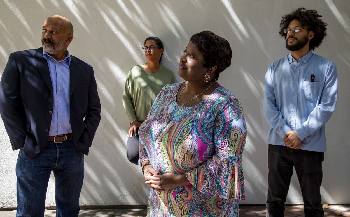 Four academics, two men and two women, standing outside