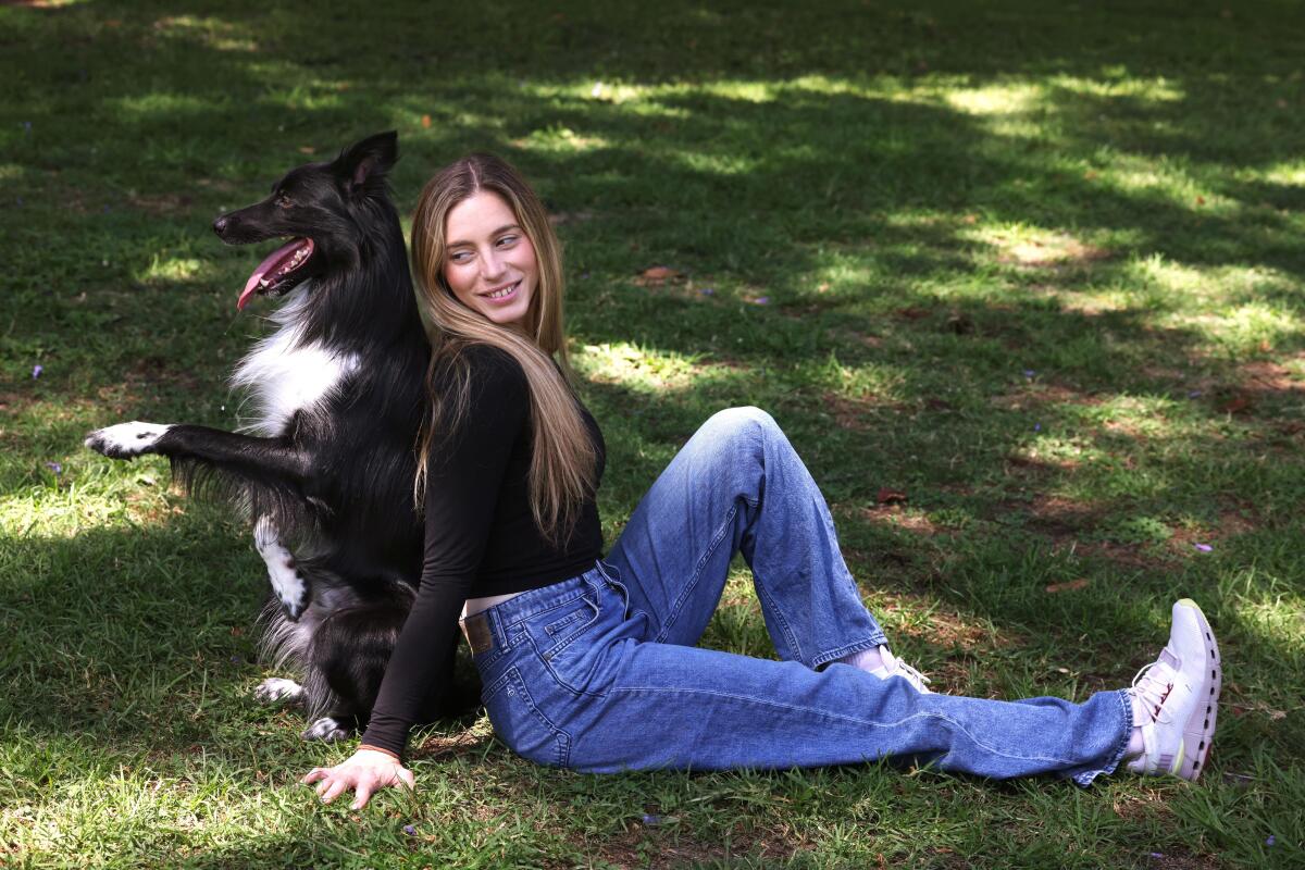 Woman sitting with her dog back to back