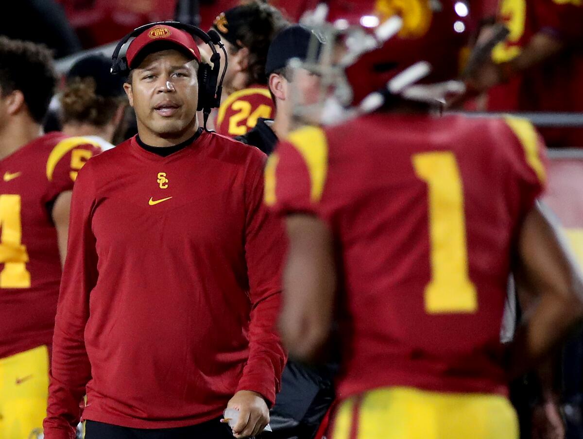 USC interim coach Donte Williams talks with players on the sideline during the Trojans' game against Utah 