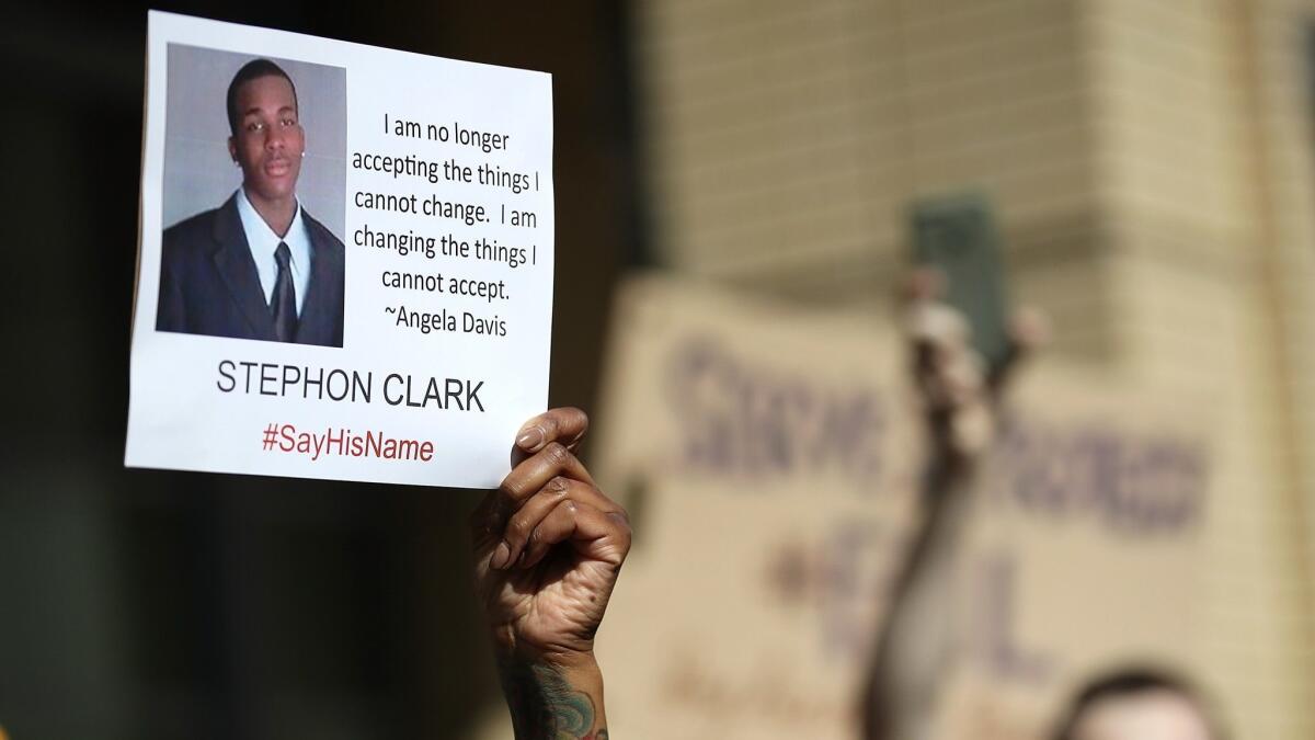 A protester holds a photo of Stephon Clark during a rally held on March 22 outside Sacramento City Hall after Clark was fatally shot by Sacramento police. Clark's family filed a wrongful death claim against the city this week.