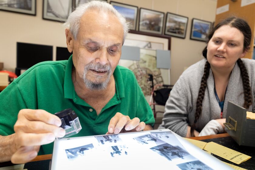 Former Times Advocate/North County Times photographer Dan Rios recently donated to Cal State San Marcos his archive of more than 40,000 photojournalism negatives taken for the newspapers from 1968 to 2002. On Tuesday, he and archivist Laura Nelson sorted through his negatives as part of the cataloging process. N photo by Don Boomer