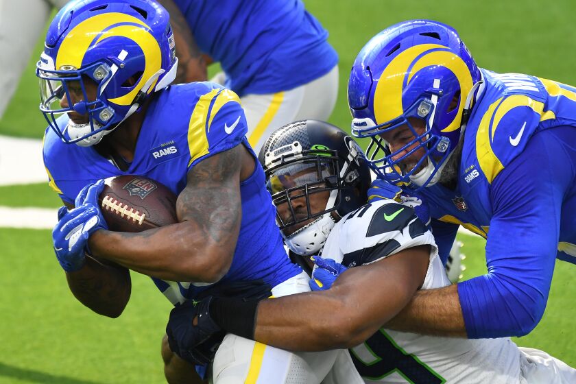 LOS ANGELES, CALIFORNIA NOVEMBER 15, 2020-Rams running back Cam Akers gets a little help from offensive lineman Andrew Whitworth to pick up yards as Seahawks linebacker Bobby Wagner makes the tackle in the 1st quarter at SoFi Stadium in Inglewood Sunday. (Wally Skalij/Los Angeles Times)