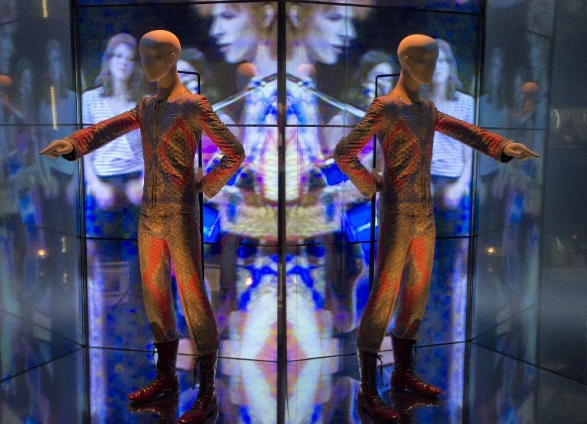 A reflection of the costume that David Bowie wore as Ziggy Stardust photographed as part of a retrospective exhibition titled "David Bowie Is," at the V&A Museum in London.