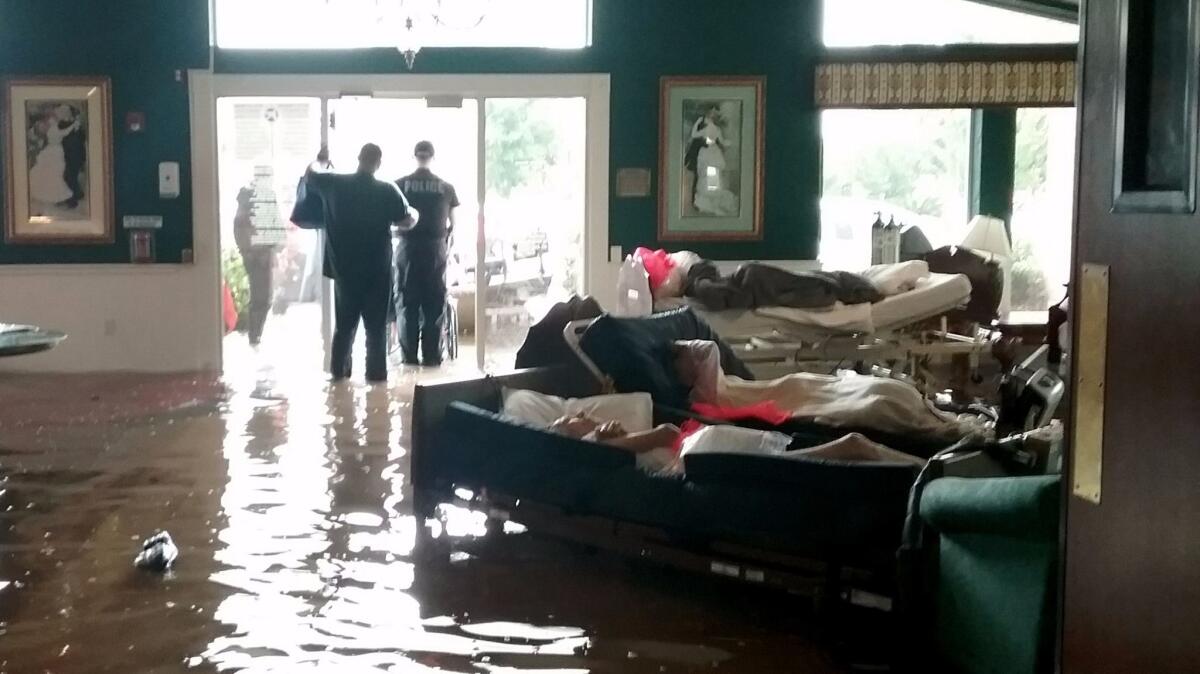 Residents lie on beds surrounded by floodwaters waiting to be evacuated from the Cypress Glen nursing home in Port Arthur, Texas, on Aug. 30, 2017.