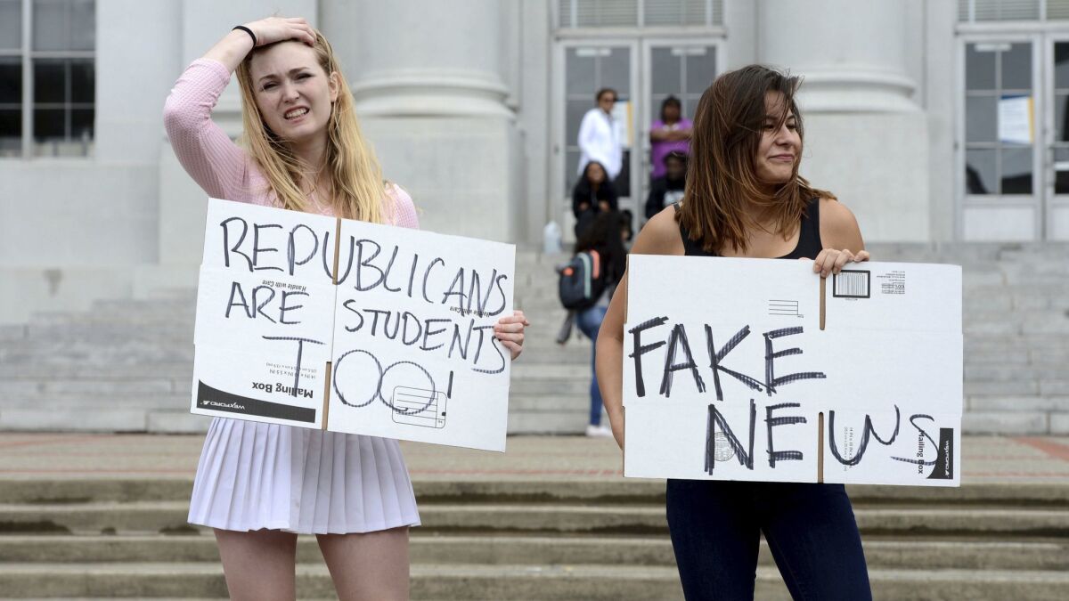 Conservative students hold signs on UC Berkeley's Sproul Plaza on April 26, 2017.