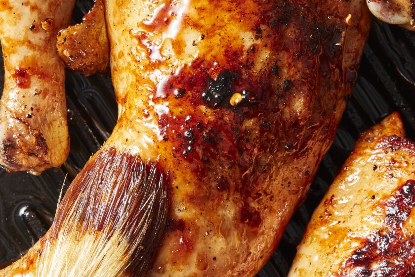 Soy glaze is brushed on grilled chicken.